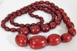 A large red amber beaded necklace 44in long approx