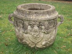 A large 19thC. reconstituted stone pot decorated with mythological figures riding dolphins holding a