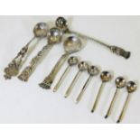 A selection of silver spoons with silver coin bowl