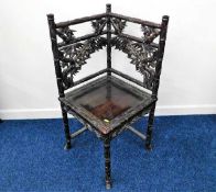 A 19thC. Chinese hardwood corner chair, carved with bamboo & leaves. Provenance: Brought back from H