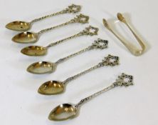 A set of six teaspoons with an added set of tongs