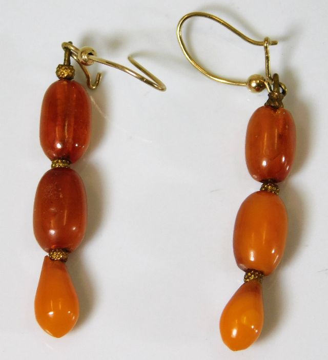 A yellow metal mounted set of c.1900 amber bead ea