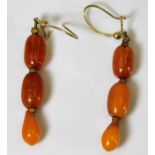 A yellow metal mounted set of c.1900 amber bead ea