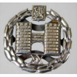 A silver badge depicting two castle turrets 5.4g