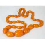A set of Edwardian amber beads with yellow metal c