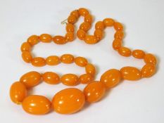 A set of Edwardian amber beads with yellow metal c