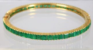 An 18ct gold emerald bangle 12.2g