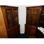 Two glazed mahogany double corner cupboards