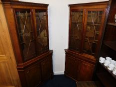 Two glazed mahogany double corner cupboards