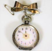 A silver ladies fob watch with silver bow, runs wh