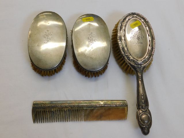 A pair of silver backed brushes, an ornate silver