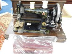 A Victorian sewing machine with a box of accessori