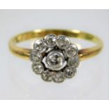A yellow metal diamond set daisy ring, rubbed mark