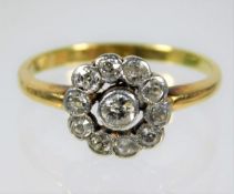 A yellow metal diamond set daisy ring, rubbed mark