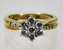 An 18ct gold diamond daisy style ring set with 0.5