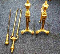 A pair of antique brass fire dogs twinned with a p