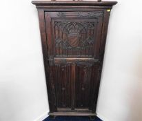 A c.1900 carved oak corner cabinet