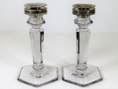 A pair of silver topped glass candle holders
