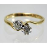 An 18ct gold crossover ring set with two diamonds,