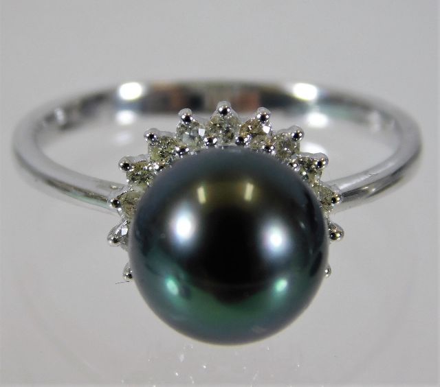 An 18ct white gold ring set with a 9mm tahitian pearl on a halo of diamonds size N/O 3.5g