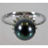 An 18ct white gold ring set with a 9mm tahitian pearl on a halo of diamonds size N/O 3.5g