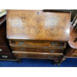 A burr walnut bureau with three drawers