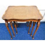 A nest of three tables with bur walnut tops