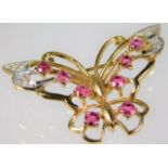 A yellow metal butterfly brooch set with diamonds