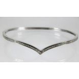 A 9ct white gold bangle set with approx. 0.61ct of