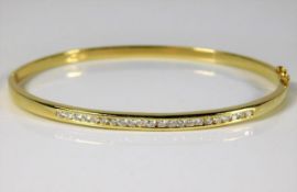An 18ct gold bangle set with approx. 0.66ct diamon