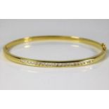 An 18ct gold bangle set with approx. 0.66ct diamon