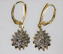 A pair of 10ct gold drop earrings set with diamond