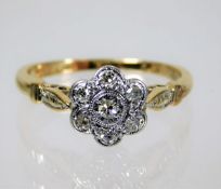 An antique 18ct gold diamond daisy ring set in pla