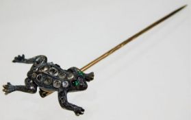 A white metal frog tie pin set with green & white