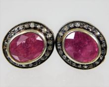 A pair of 9ct gold & silver earrings set with ruby