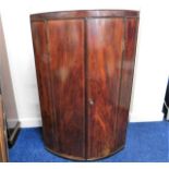 A 19thC. mahogany cylindrical corner cabinet