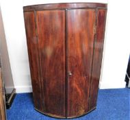 A 19thC. mahogany cylindrical corner cabinet