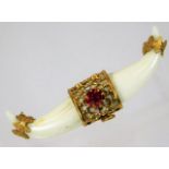 A 19thC. mounted carved marine ivory claw style brooch lacking pin set with red stone