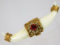 A 19thC. mounted carved marine ivory claw style brooch lacking pin set with red stone