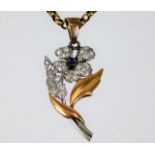 An early 20thC. two colour metal flower, tests as 18ct gold, set with diamond & cabochon cut sapphir