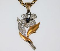 An early 20thC. two colour metal flower, tests as 18ct gold, set with diamond & cabochon cut sapphir