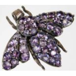 A silver moth brooch set with amethyst style stone