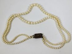 A vintage double string of pearls with silver clas
