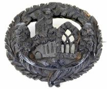 A 19thC. Irish bog oak carved brooch inscribed Muc