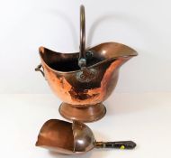 A copper helmet shaped coal bucket with coal scoop