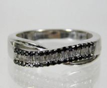 A 9ct white gold crossover ring set with white & b