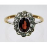 A 9ct gold ring with platinum set garnet & white s