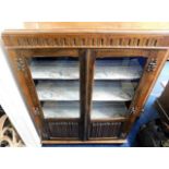 An oak glazed bookcase with linen fold doors