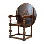 Reproduction oak monks chair having a circular up-and-over top/back and standing on turned