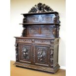 19th Century heavily carved dark oak chiffonier, the raised back having a carved pediment with